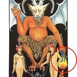 悪魔の左手の下に向けた松明(たいまつ)